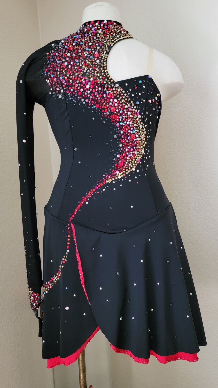 Custom figure skating dress, black one-shoulder with red and gold rhinestone swirl